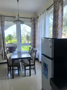 a dining room with a table and chairs and a refrigerator at Sunrise-Nyali, Mombasa in Nyali