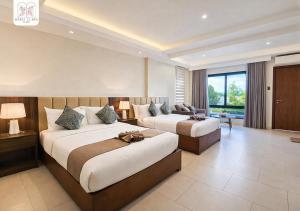 a hotel room with two beds and a couch at Maria Clara Villas in Panabo