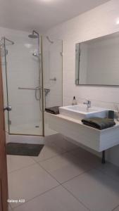 a bathroom with a sink and a shower and a mirror at Appartement duplex F2 in Koné +5 photos