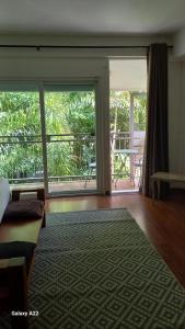 a living room with a large sliding glass door with a balcony at Appartement duplex F2 in Koné