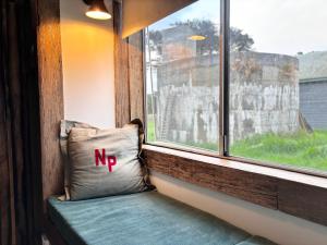 a pillow with the letter n on it sitting in a window at Bluff Shacks in Whitemark