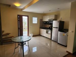 a kitchen with a table and a refrigerator at Appartement duplex F2 in Koné