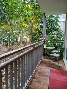 a balcony with a chair and a table and trees at Appartement duplex F2 in Koné