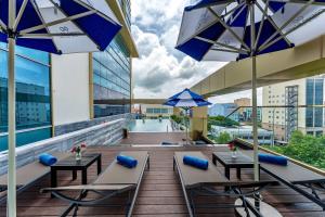 a balcony with tables and umbrellas on a building at Cosmo Stars Hotel Bạc Liêu in Bạc Liêu