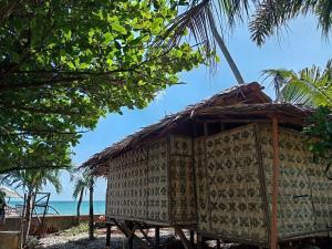 a hut on the beach with the ocean in the background at RENDER VOUS A'l MER in Puerto Princesa City