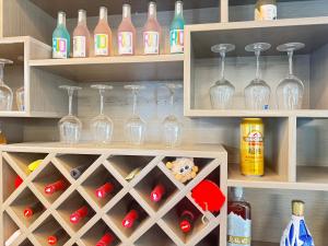 a cabinet filled with wine glasses and wine bottles at MEI DI DU JIA HOTEL in Shanghai