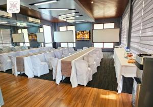 a conference room with white tables and white chairs at Maria Clara Villas in Panabo +8 photos
