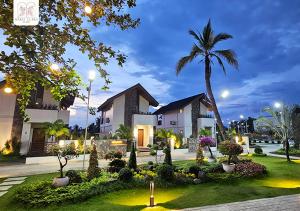 a villa with a palm tree and a building at Maria Clara Villas in Panabo