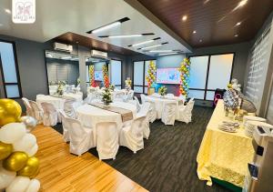 a banquet room with white tables and white chairs at Maria Clara Villas in Panabo