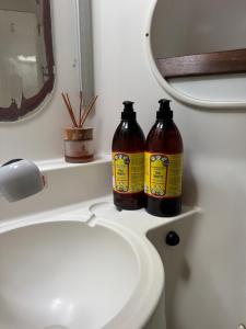 two bottles of honey sitting on a bathroom sink at Nuit insolite sur un catamaran in Paopao