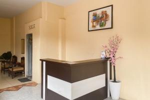 a lobby with a counter with a vase of flowers at RedDoorz at Hotel Warna Palopo in Palopo