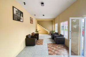 a waiting room with couches and stairs in a building at RedDoorz at Hotel Warna Palopo in Palopo