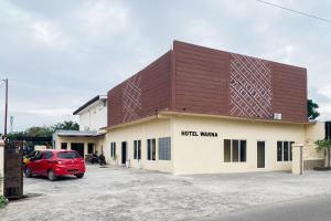 a building with a red car parked in a parking lot at RedDoorz at Hotel Warna Palopo in Palopo +17 photos
