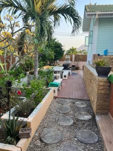 a garden with benches and plants on a house at Charming quirky Thai style house in Hua Hin
