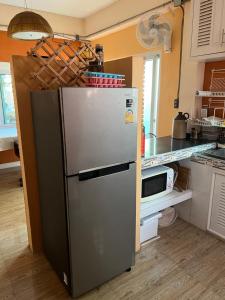 a kitchen with a stainless steel refrigerator in a kitchen at Charming quirky Thai style house in Hua Hin