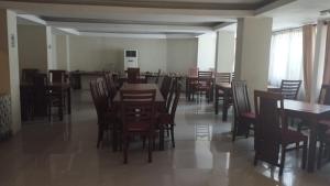 a dining room with wooden tables and chairs at Hotel GRANDSARASWATI in Stasiun Poncol +5 photos