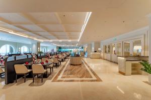 a restaurant with tables and chairs in a lobby at Cosmo Stars Hotel Bạc Liêu in Bạc Liêu