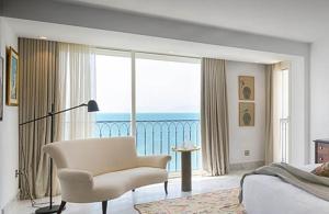 a bedroom with a chair and a view of the ocean at ksour in Tunis