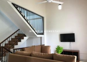 a living room with a couch and a staircase at Nirmalahomestay in Polgasowita