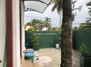 a palm tree and two toilets in a courtyard at Nirmalahomestay in Polgasowita