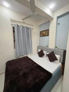 a bedroom with a large bed with a window at Khandelwal Guest House in Ujjain