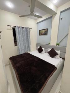 a bedroom with a bed with a brown blanket on it at Khandelwal Guest House in Ujjain +9 photos