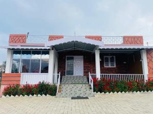a brick house with red flowers in front of it at Sky High Villa - Ooty in Ooty +9 photos