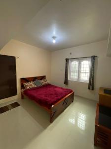 a bedroom with a bed and a television in it at Sky High Villa - Ooty in Ooty