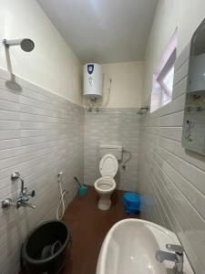 a small bathroom with a toilet and a sink at Sky High Villa - Ooty in Ooty