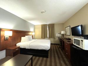 a hotel room with a bed and a tv at Americas Best Value Inn Fargo in Fargo