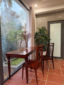 a dining room table with two chairs and a window at Peaceful Hilltop Duplex Central Phu Quoc in Phú Quốc