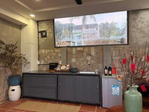 a kitchen with a counter and a stone wall at Peaceful Hilltop Duplex Central Phu Quoc in Phú Quốc +14 photos
