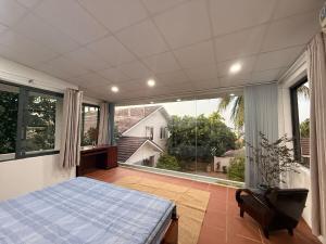 a bedroom with a bed and a large window at Peaceful Hilltop Duplex Central Phu Quoc in Phú Quốc