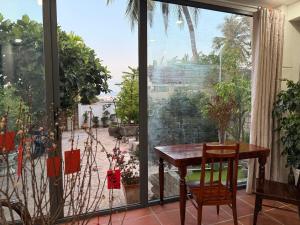 a table and chairs in a room with a large window at Peaceful Hilltop Duplex Central Phu Quoc in Phú Quốc