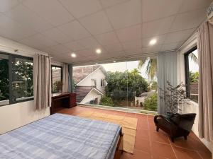 a bedroom with a bed and a large window at Peaceful Hilltop Duplex Central Phu Quoc in Phú Quốc
