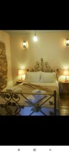 a bedroom with a bed with two lights and two tables at Summer House in Corfu Town in Mantoúkion
