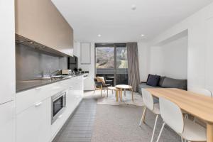 a kitchen and living room with a table and chairs at Squatters Run 26 in Thredbo