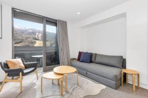 a living room with a couch and a table and chairs at Squatters Run 26 in Thredbo