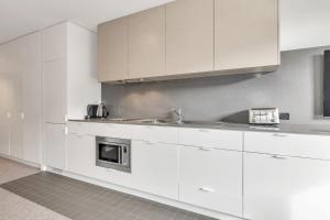 a kitchen with white cabinets and a sink at Squatters Run 26 in Thredbo