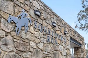 a sign on a building with two horses on it at Squatters Run 26 in Thredbo +2 photos