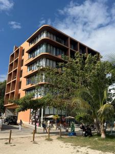 a tall building with a palm tree in front of it at Beach Studio Playa del Carmen MX in Playa del Carmen