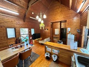 a living room with wooden walls and a wooden table at Mori Vila Aso in Takamori