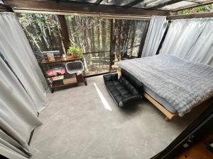a bedroom with a bed in a room with a window at Mori Vila Aso in Takamori