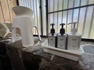 a group of three bottles of soap on a counter at Mori Vila Aso in Takamori