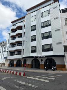 a white building with a motorcycle parked in front of it at Toàn Thịnh Hotel in Da Lat