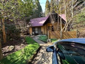 a car parked in front of a yellow house at Mori Vila Aso in Takamori +4 photos