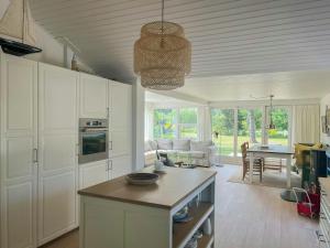 a kitchen with white cabinets and a living room at Holiday Home At Fynshoved in Martofte +29 photos