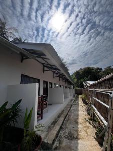 a white building with a cloudy sky in the background at SALWA Homestay in Kuta Lombok