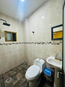 a bathroom with a toilet and a sink at Hospedaje chachalacas in Chachalacas +34 photos