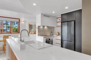 a kitchen with a white counter top and a refrigerator at Nouvelle in Noosaville